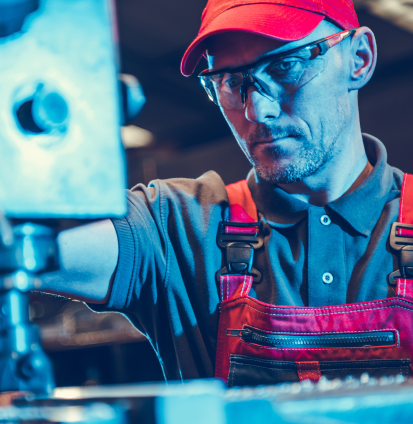 Operario especializado de Mecanizados Cerveró supervisando proceso de mecanizado CNC en taller industrial de Valencia