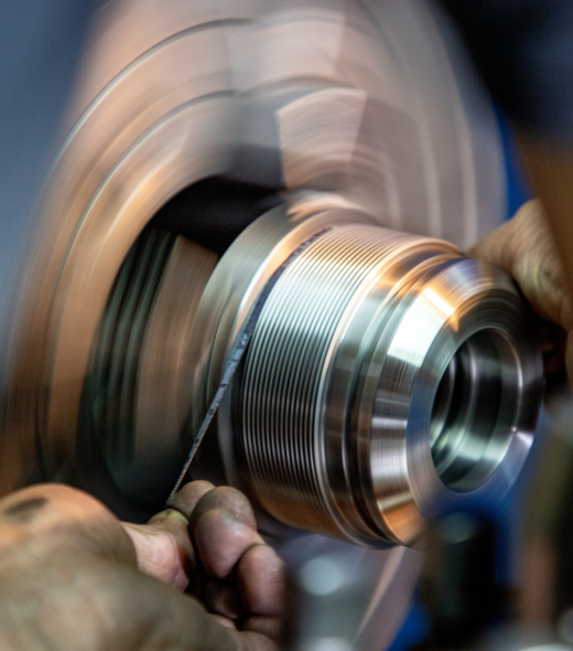 Operario controlando pieza roscada en torno CNC con acabado de alta calidad en Mecanizados Cerveró Valencia